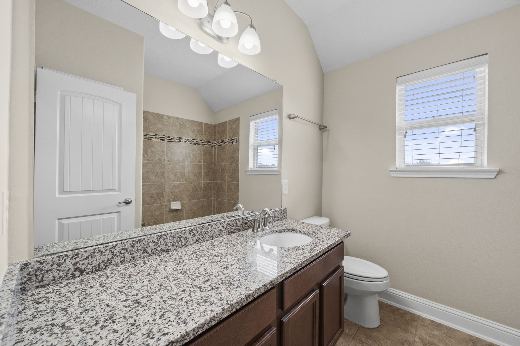 8507 Clarkman Ridge Lane Cypress, TX 77433 - Photo 37 of 48 a bathroom with a granite countertop sink a toilet and a mirror