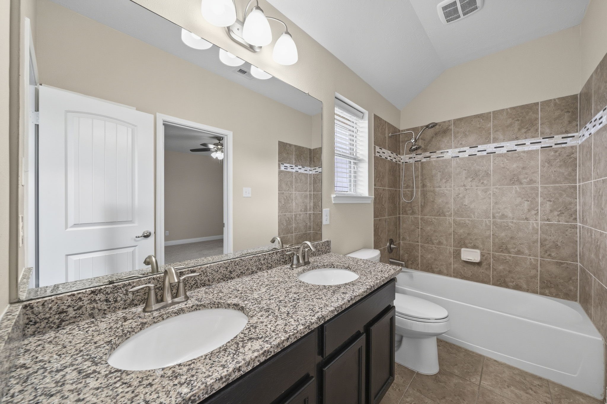 8507 Clarkman Ridge Lane Cypress, TX 77433 - Photo 42 of 48 a bathroom with a granite countertop sink a toilet a mirror a bathtub and shower