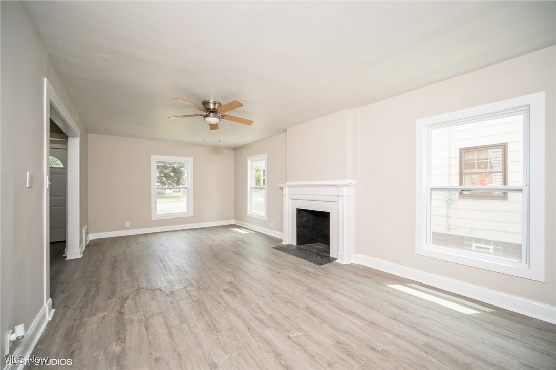 2188 North Taylor Road Cleveland Heights, OH 44112 - Photo 3 of 15 Unfurnished living room featuring wood finished floors, a ceiling fan, and a fireplace with flush hearth