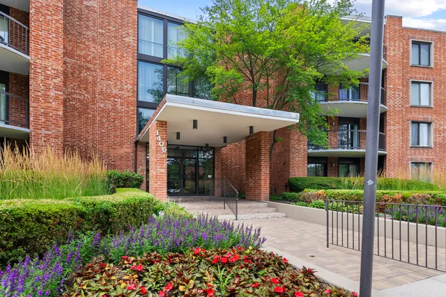 a view of a house with a small yard and flower plants