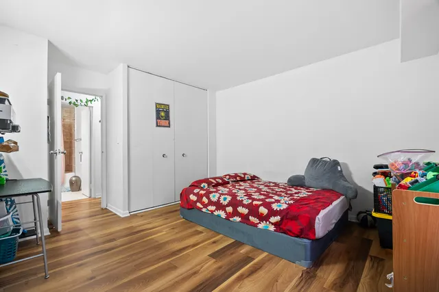 a bedroom with a bed a dresser and book shelf