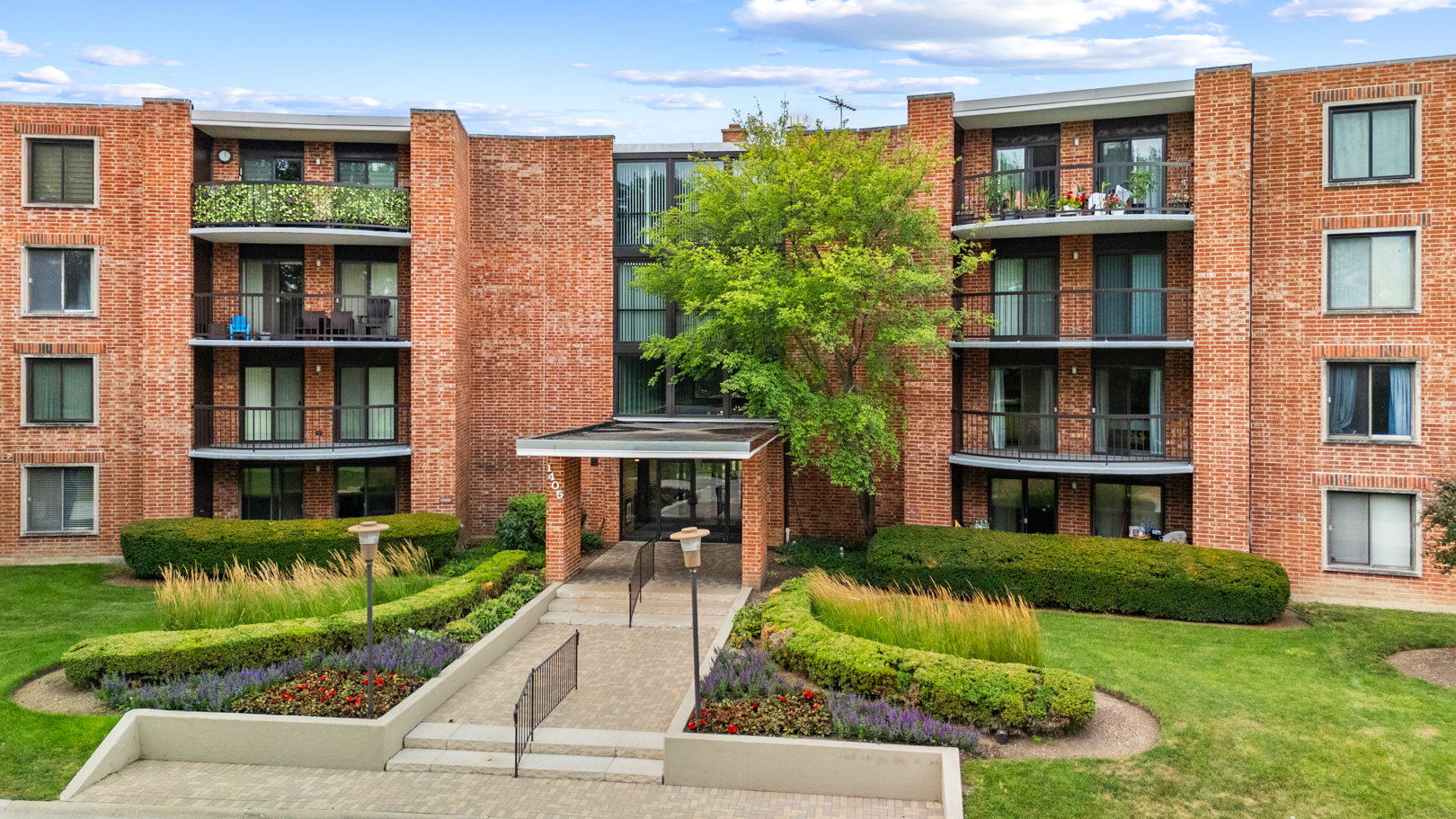 1405 East Central Road, Unit 110B Arlington Heights, IL 60005 - Photo 2 of 24 a front view of a residential apartment building with a yard
