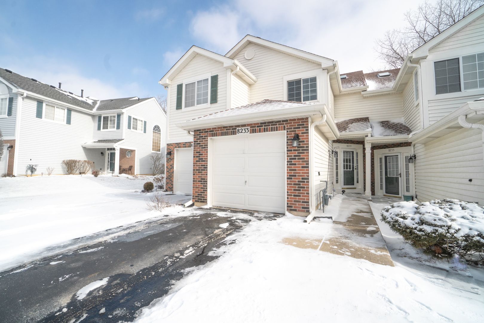 8233 Ripple Ridge, Unit 8233 Darien, IL 60561 - Photo 1 of 18 a front view of a house with a yard and garage