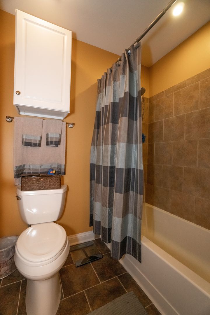 8233 Ripple Ridge, Unit 8233 Darien, IL 60561 - Photo 15 of 18 a bathroom with a toilet and a shower