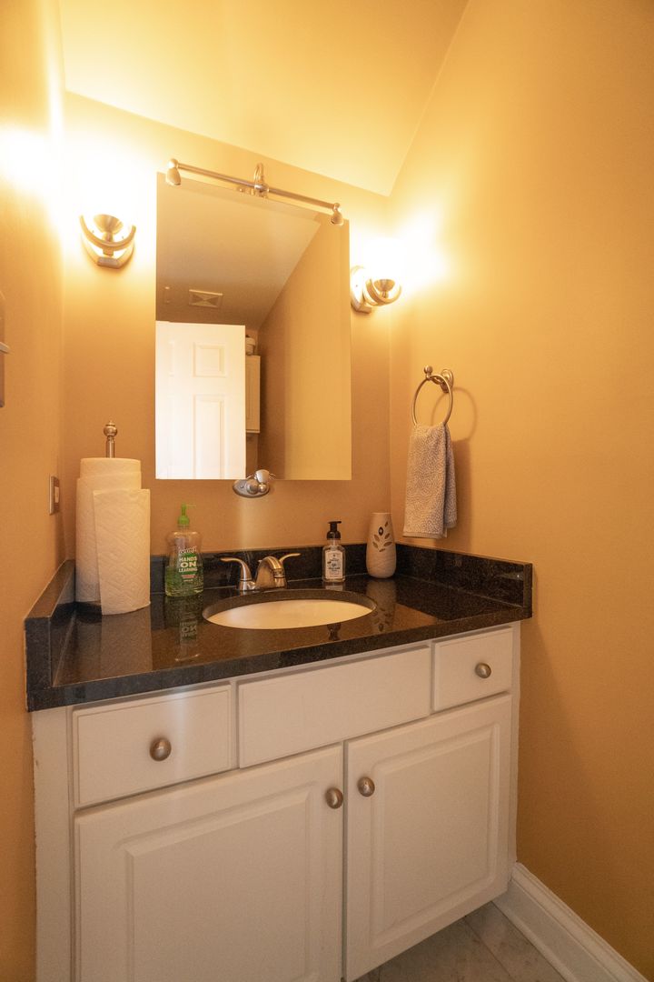 8233 Ripple Ridge, Unit 8233 Darien, IL 60561 - Photo 10 of 18 a bathroom with a granite countertop sink and a mirror