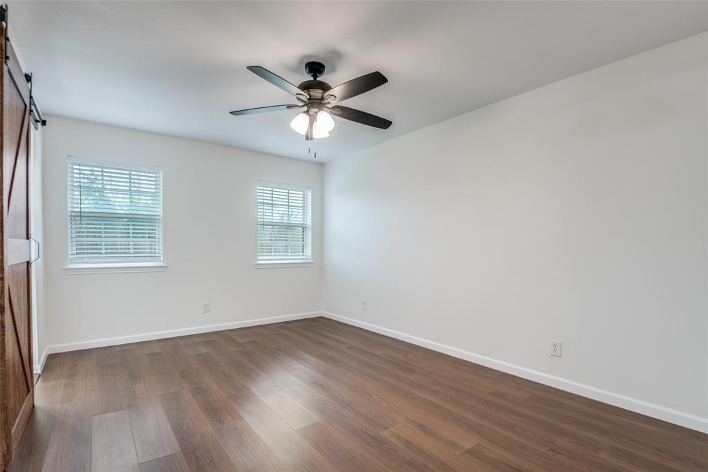 1055 Wright Street Terrell, TX 75160 - Photo 14 of 20 an empty room with wooden floor fan and windows