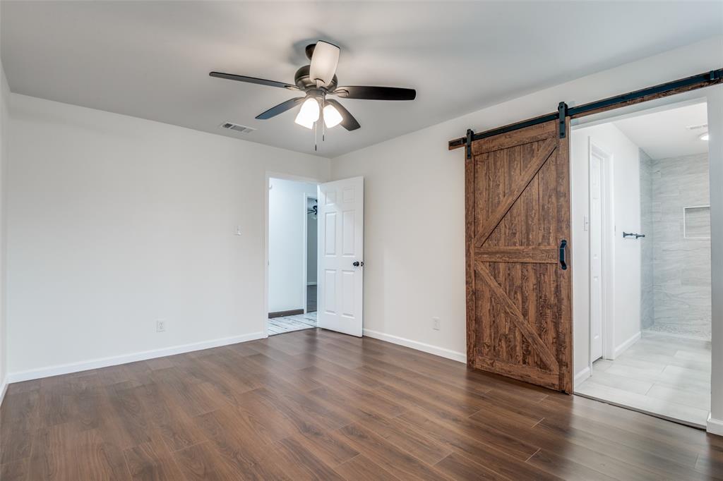 1055 Wright Street Terrell, TX 75160 - Photo 15 of 20 a view of an empty room with wooden floor and a ceiling fan