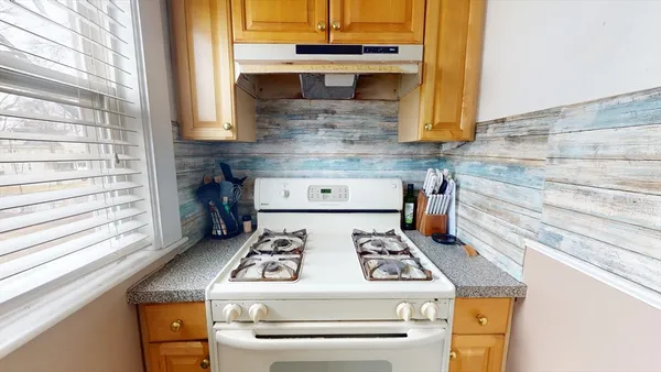 a white stove top oven sitting inside of a kitchen