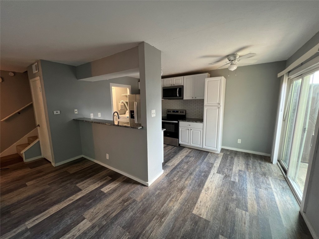 wooden floor in an empty room with a kitchen