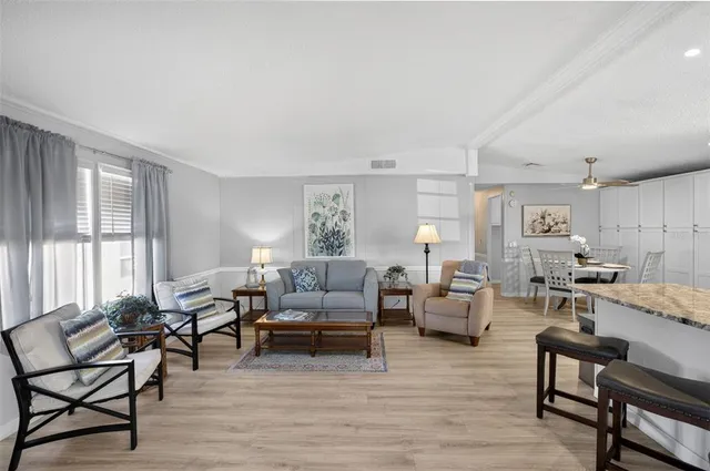 a living room with furniture floor to ceiling window and a flat screen tv