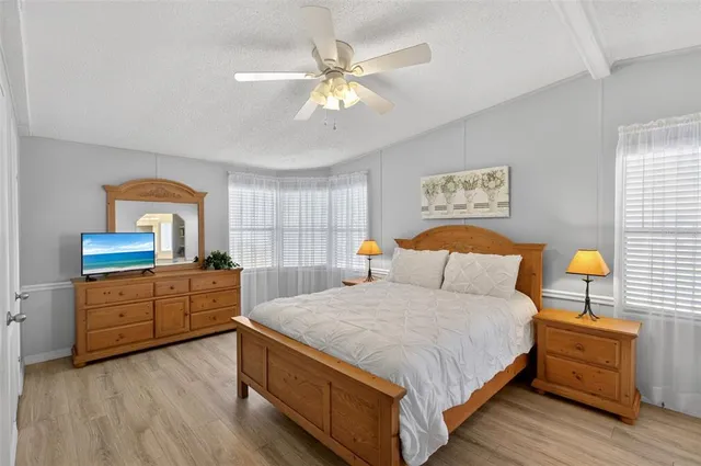 a bedroom with a large bed and a chandelier
