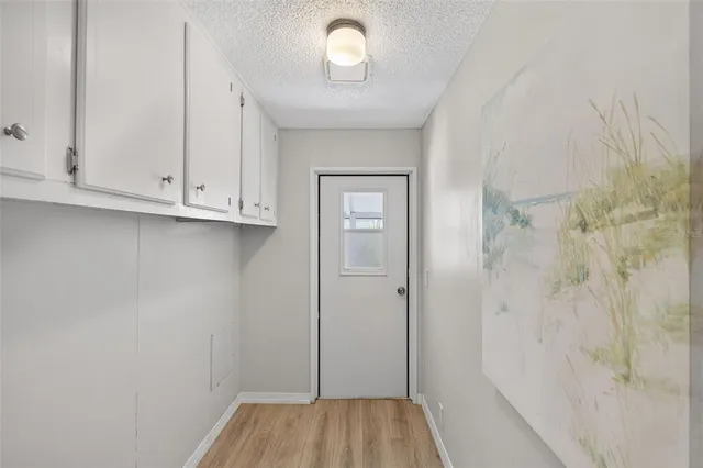 a kitchen with stainless steel appliances kitchen island granite countertop a dining table chairs and a refrigerator