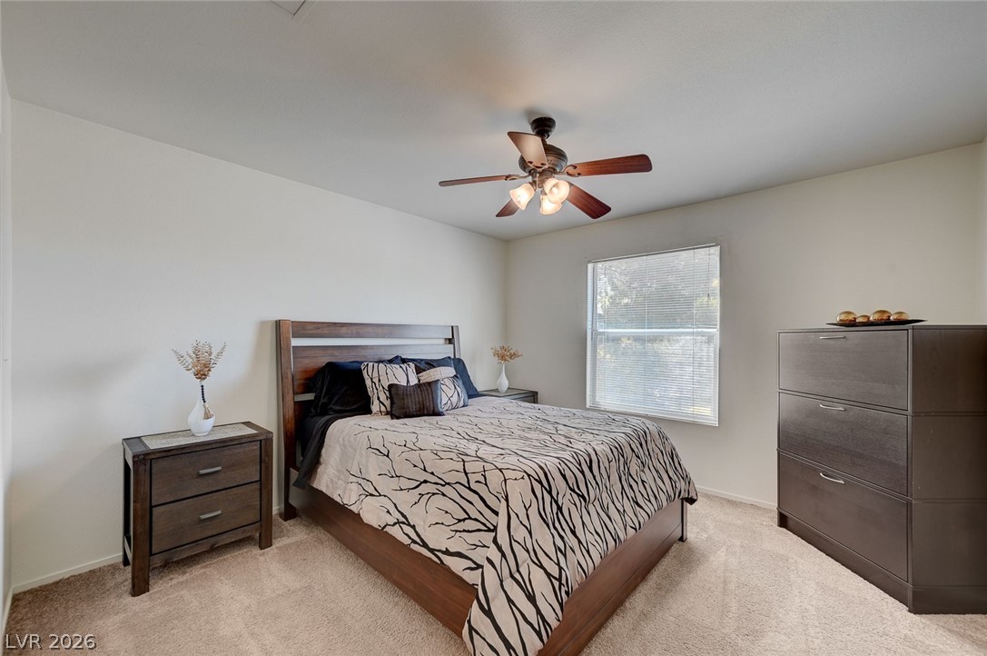555 East Silverado Ranch Boulevard, Unit 2124 Las Vegas, NV 89183 - Photo 24 of 47 Well-lit bedroom offers comfortable living, complete with soft carpeting and a ceiling fan for year-round comfort.