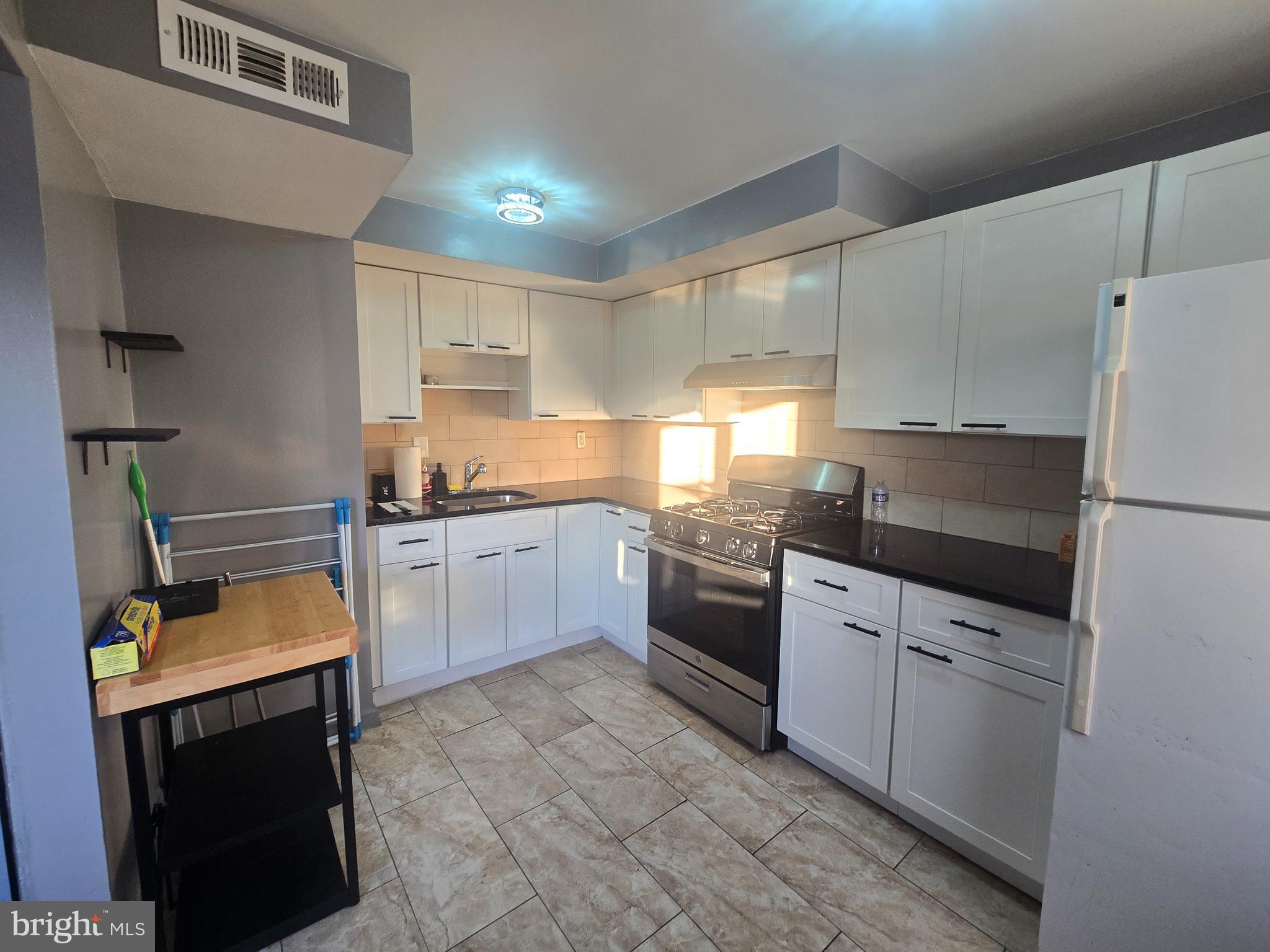 529 Foster Street Philadelphia, PA 19116 - Photo 7 of 17 a kitchen with granite countertop a refrigerator stove top oven and sink