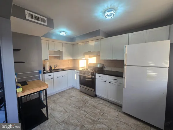 a kitchen with granite countertop stainless steel appliances and white cabinets
