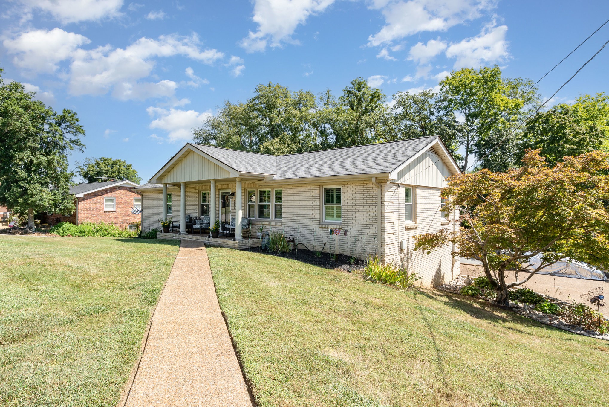 a front view of a house with yard patio and green space
