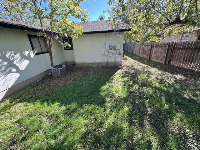 a backyard of a house with table and chairs