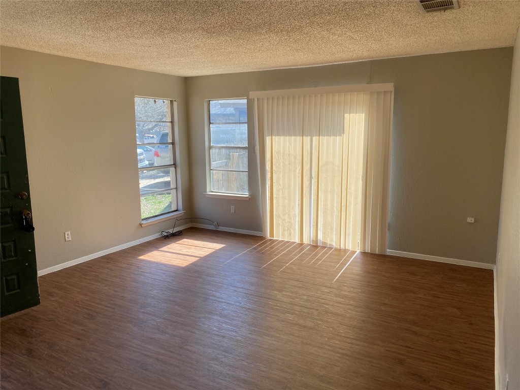 5202 Bogey Court, Unit A Austin, TX 78744 - Photo 2 of 15 an empty room with wooden floor and windows