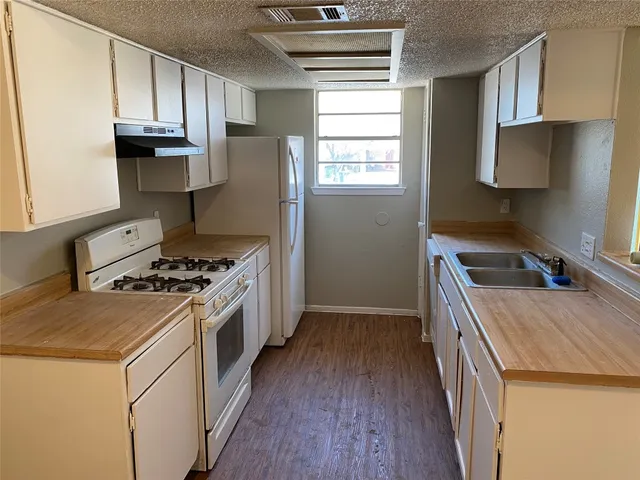a kitchen with a stove a sink and a refrigerator