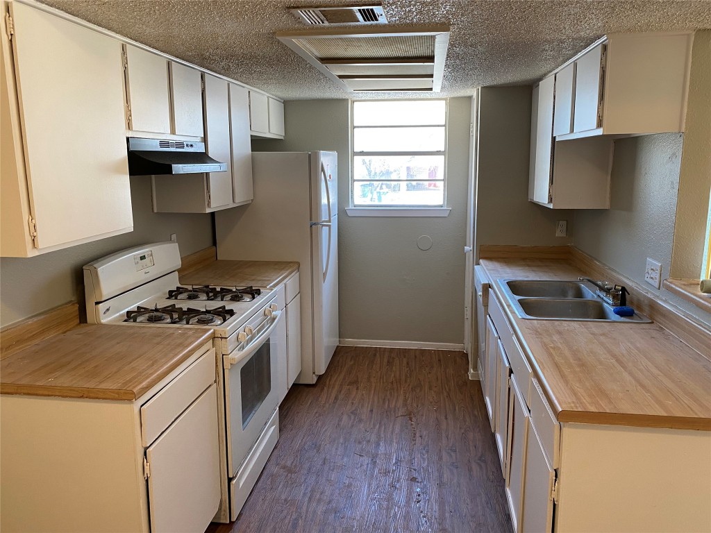 5202 Bogey Court, Unit A Austin, TX 78744 - Photo 10 of 15 a kitchen with a stove a sink and a refrigerator
