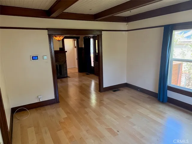 a view of a room with wooden floor and a window