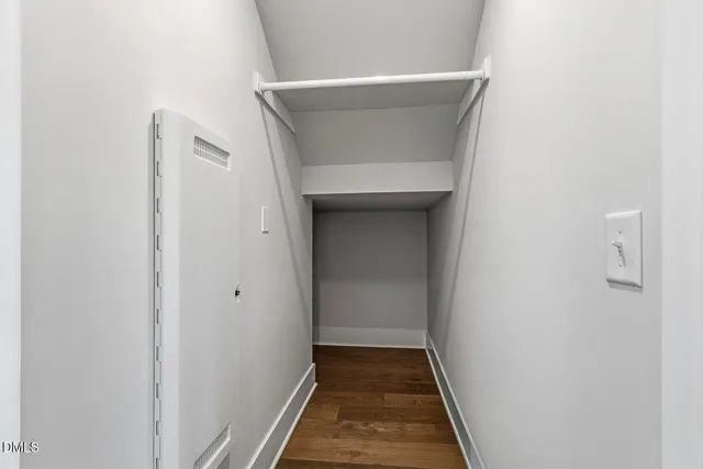 a view of a room with wooden floor a ceiling fan and windows