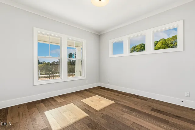 a kitchen with stainless steel appliances white cabinets and a wooden floors