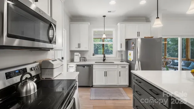 a kitchen with stainless steel appliances a stove refrigerator sink and cabinets