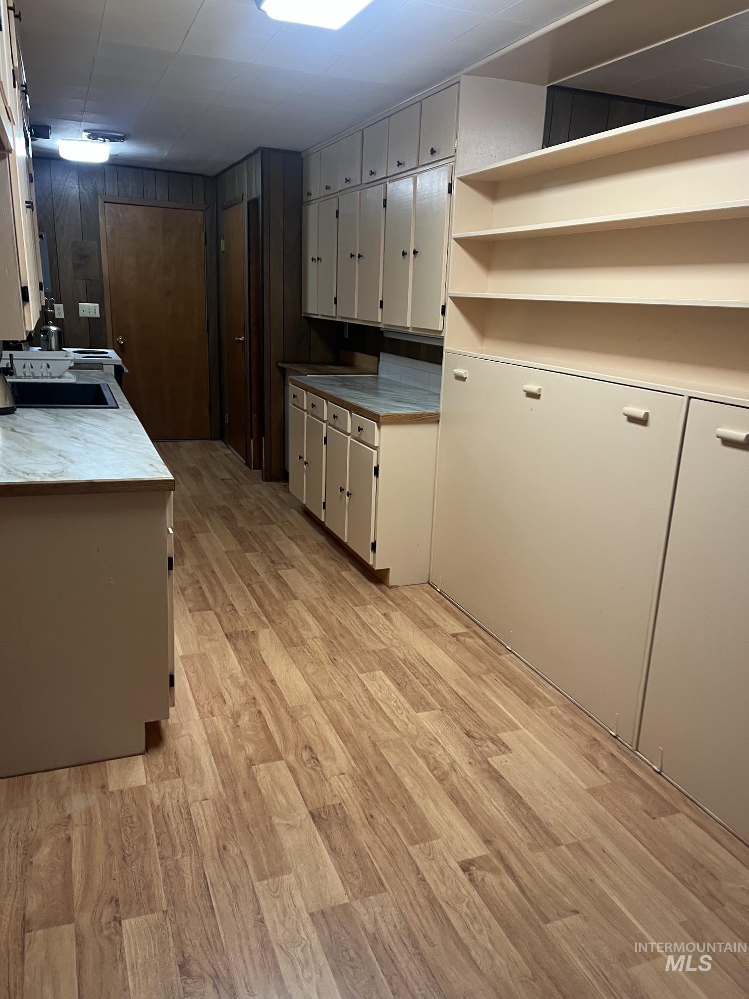 39 Mayflower Mine Road Placerville, ID 83666 - Photo 25 of 36 Kitchen featuring extensive cabinetry, wood-finish flooring, light-toned countertops, and built-in shelving