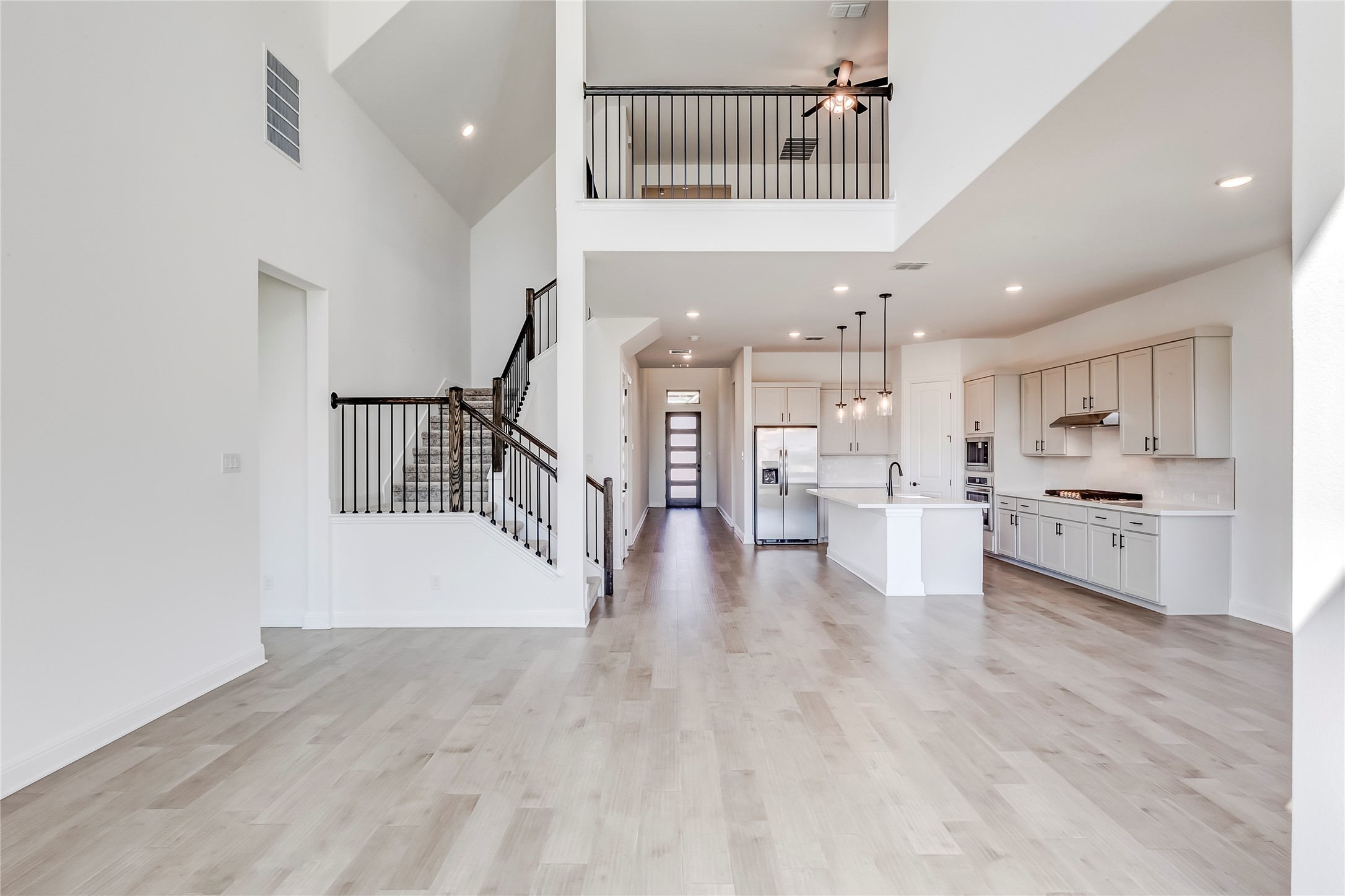 920 Old Gdn Road Leander, TX 78641 - Photo 8 of 39 Unfurnished living room with a towering ceiling, stairs, light wood-type flooring, recessed lighting, and ceiling fan