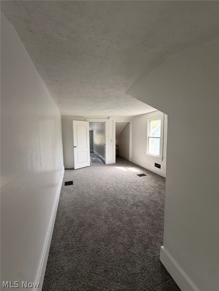 908 Palmyra Road Southwest Warren, OH 44485 - Photo 16 of 25 Textured ceiling, light gray walls, dark gray carpeting, white trim, and a double-hung window