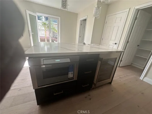 a kitchen with a stove a sink and wooden floor
