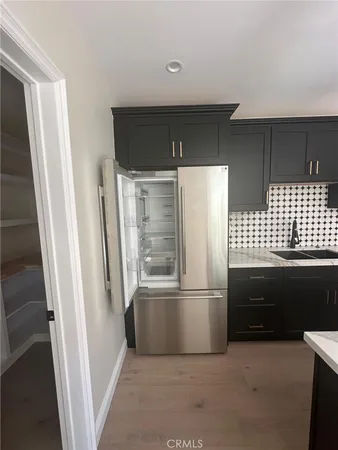 a kitchen with a sink and chairs