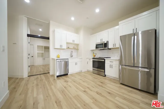 a kitchen with stainless steel appliances a refrigerator sink and microwave
