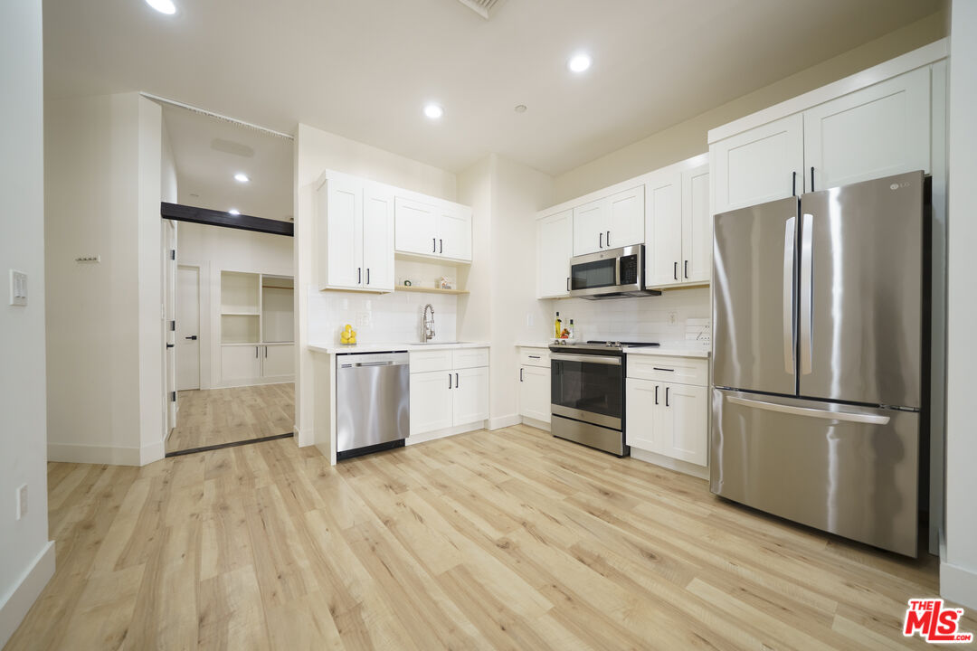 a kitchen with stainless steel appliances a refrigerator sink and microwave