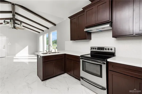 a kitchen with granite countertop wooden cabinets and a stove top oven