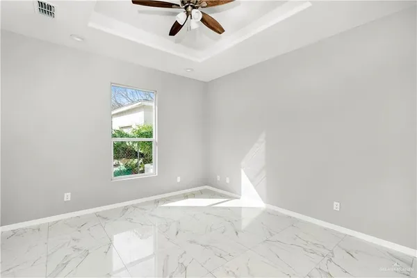 an empty room with a window and a ceiling fan