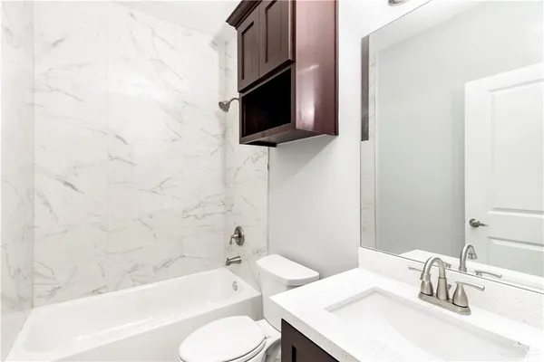a bathroom with a sink toilet a mirror and bathtub