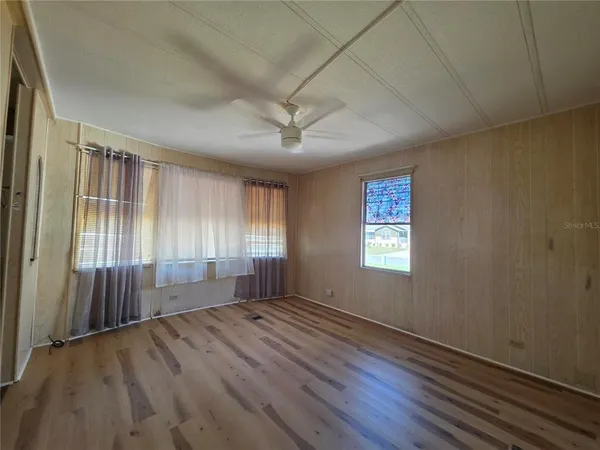 a view of a livingroom with a ceiling fan and window