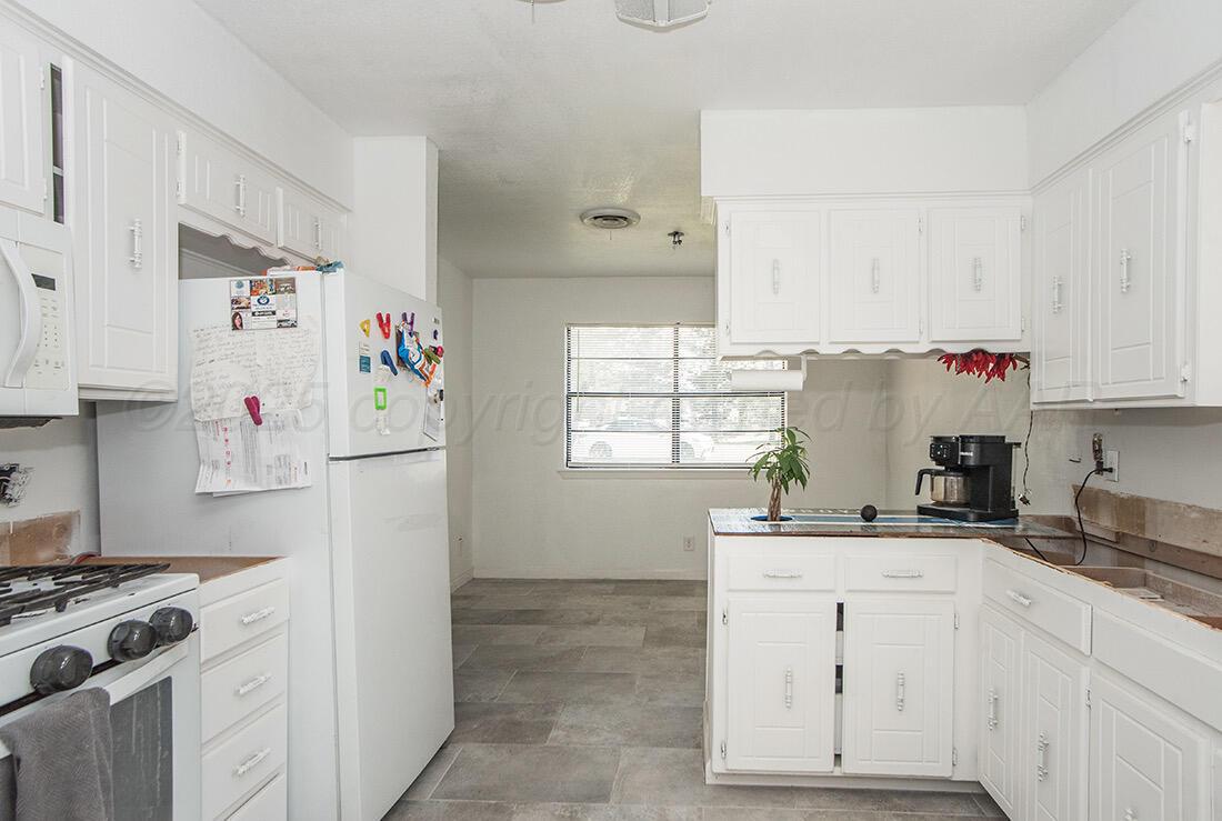 4206 Arden Road Amarillo, TX 79110 - Photo 11 of 26 a kitchen with a sink stove and white cabinets