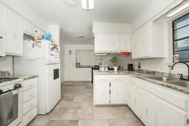 a kitchen with cabinets appliances a sink and a counter top space