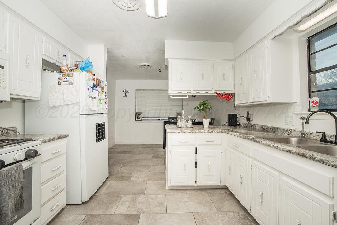 4206 Arden Road Amarillo, TX 79110 - Photo 7 of 26 a kitchen with cabinets appliances a sink and a counter top space