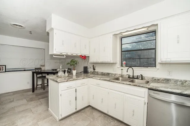 a kitchen with a sink dishwasher stove and cabinets