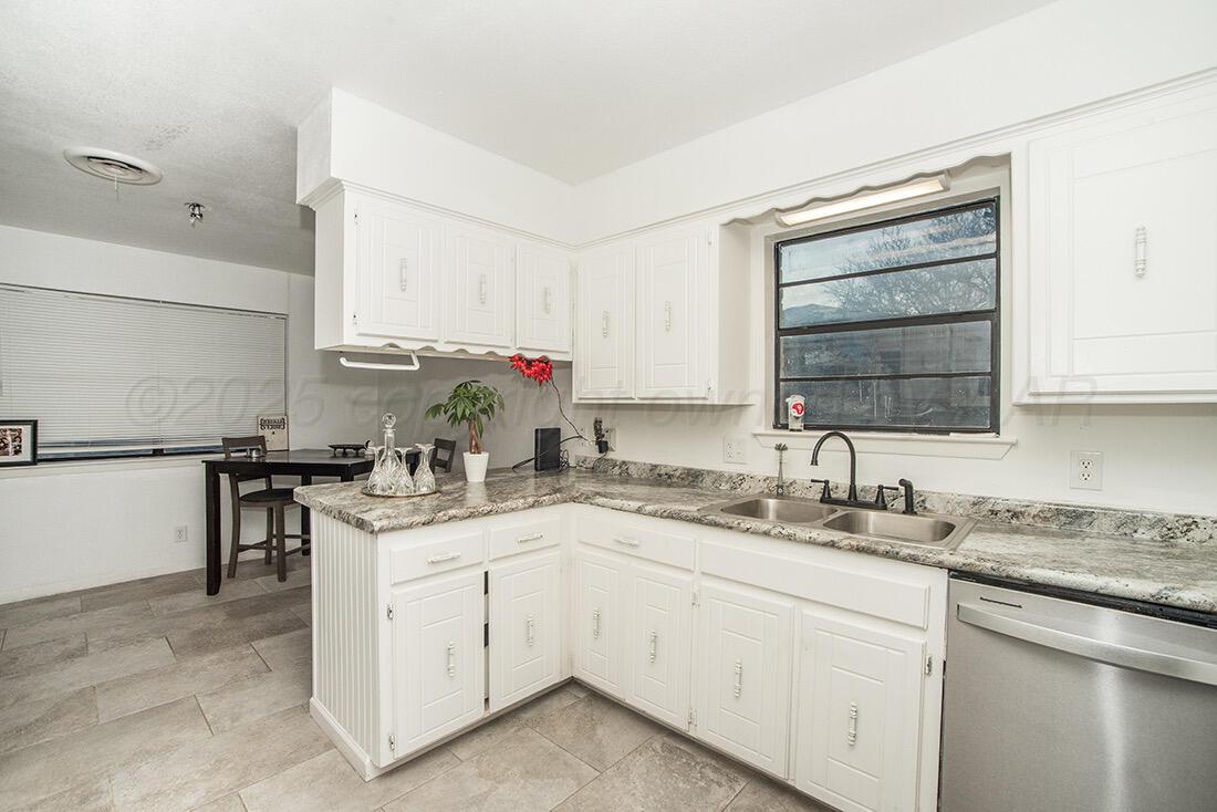 4206 Arden Road Amarillo, TX 79110 - Photo 8 of 26 a kitchen with a sink dishwasher stove and cabinets