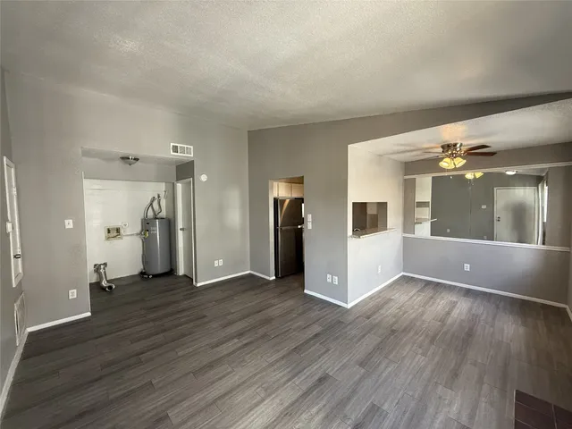 a view of a big room with wooden floor and windows