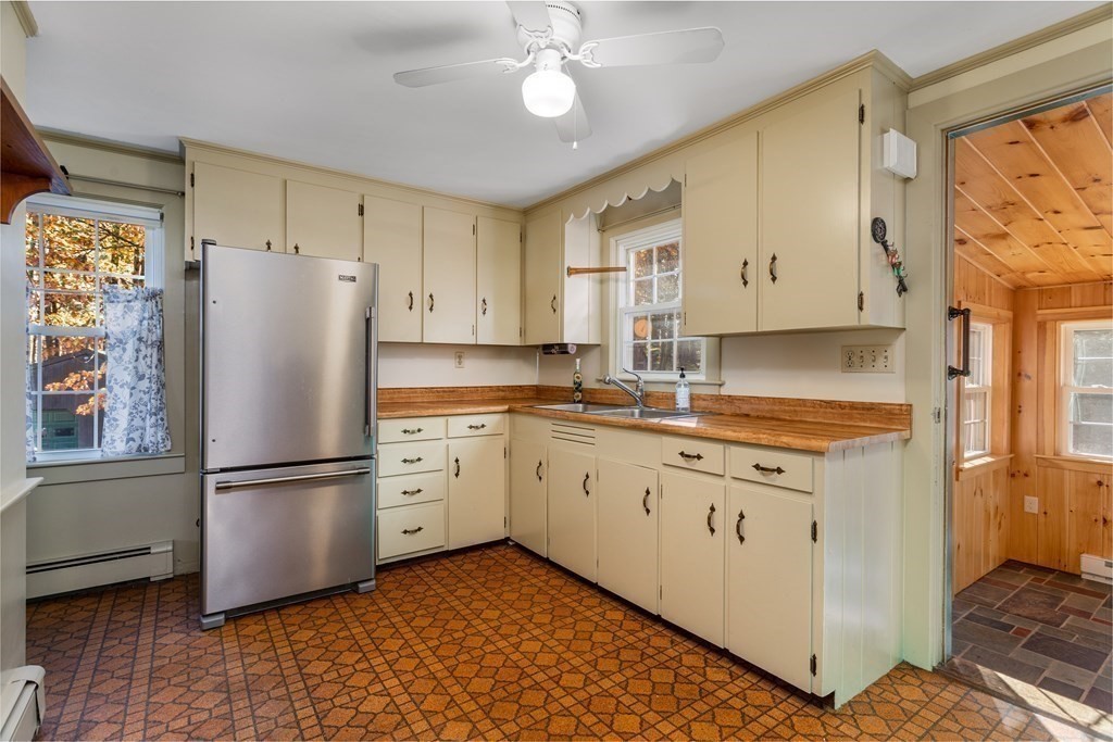 589 Turnpike Road Ashby, MA 01431 - Photo 12 of 40 a kitchen with granite countertop a refrigerator a sink and white cabinets