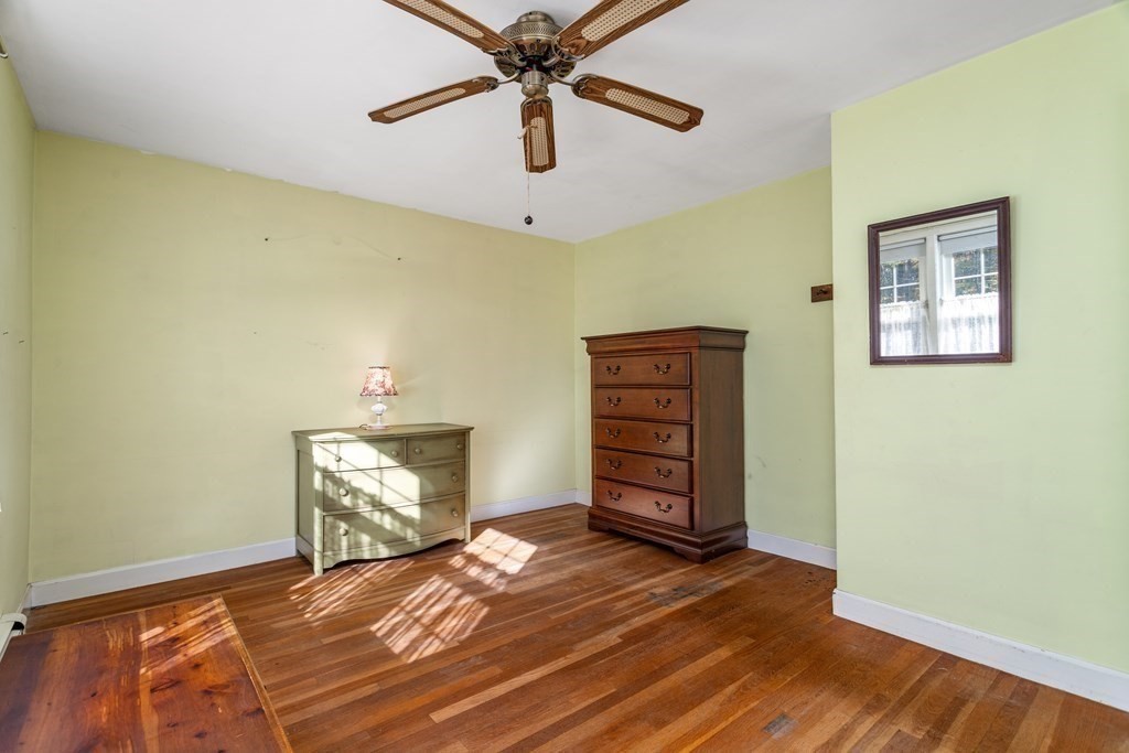 589 Turnpike Road Ashby, MA 01431 - Photo 21 of 40 a view of a bedroom with a bed and a ceiling fan