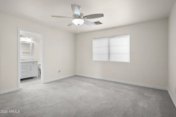 an empty room with windows and fan