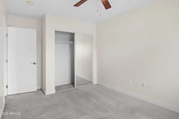 an empty room with a ceiling fan and a window