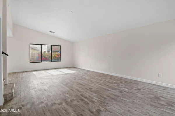 wooden floor in an empty room with a window